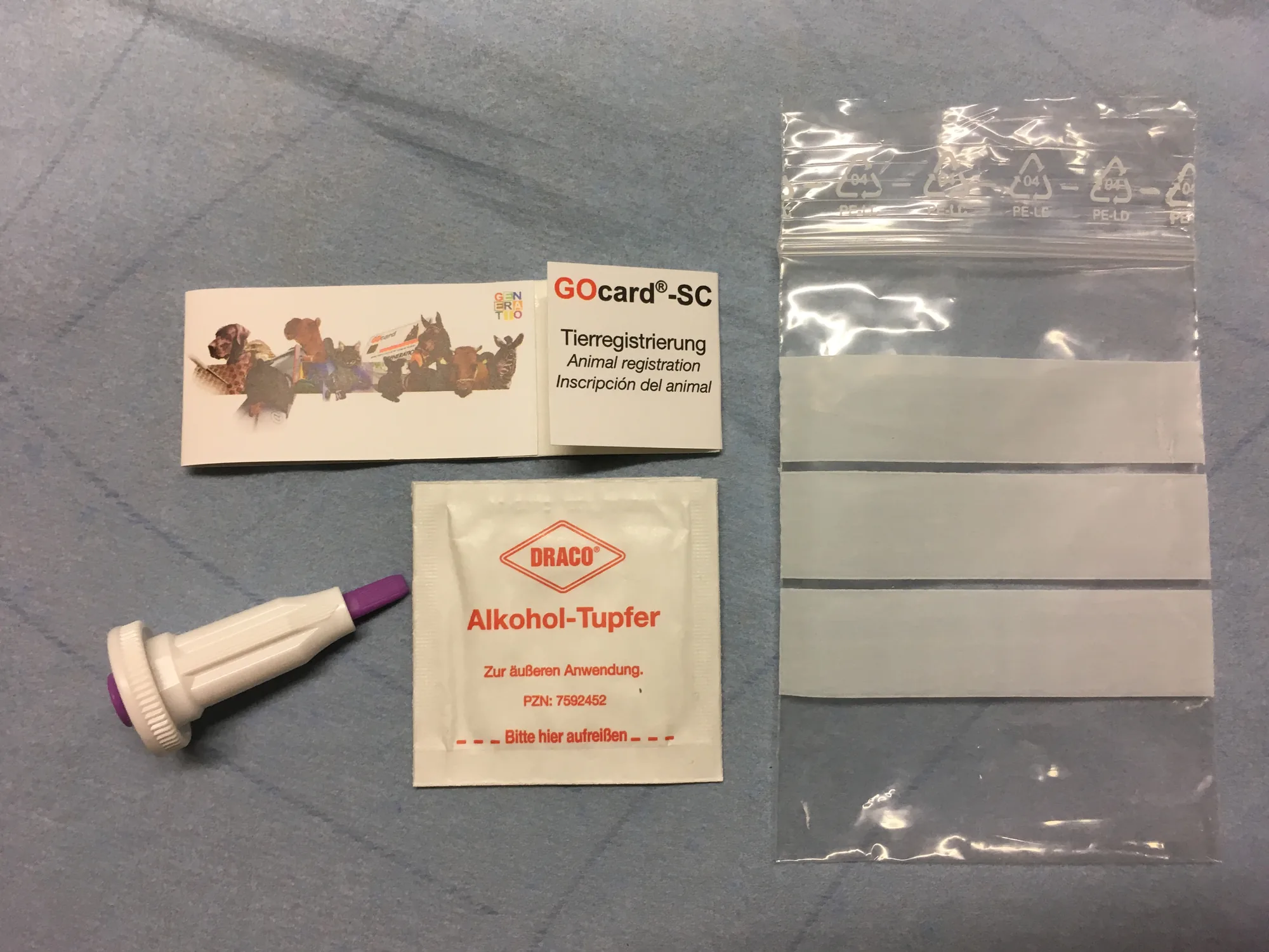 GOcard-SC set for animal registration: opened sample card, lancet, alcohol swab and shipping bag.